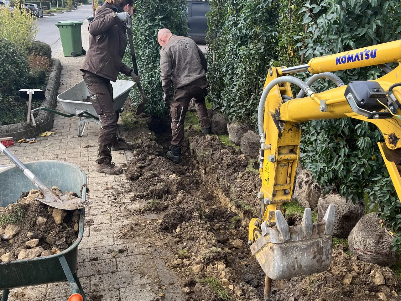 Plantation d'une haie à la mini-pelle par l'équipe FEIERMAX, le long d'une allée